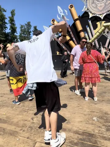 Festival crowd on a wooden floor in front of a stage with golden cannons